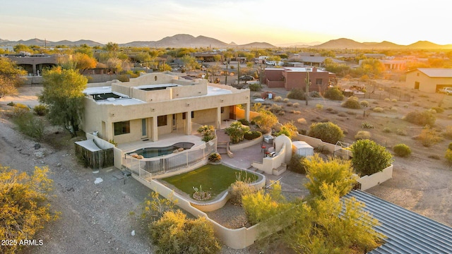 aerial view at dusk featuring a mountain view and a residential view