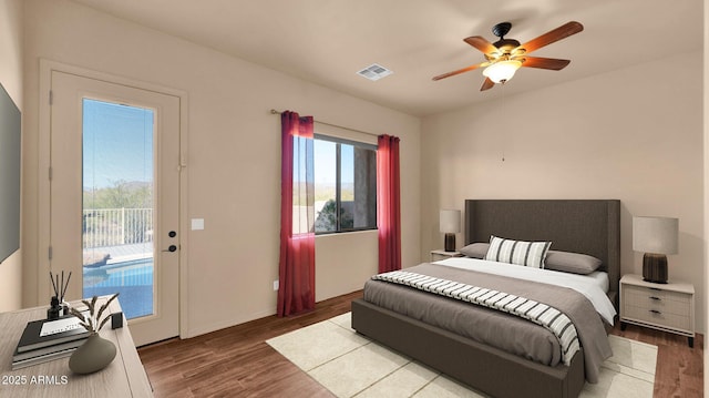 bedroom with visible vents, wood finished floors, access to exterior, and a ceiling fan