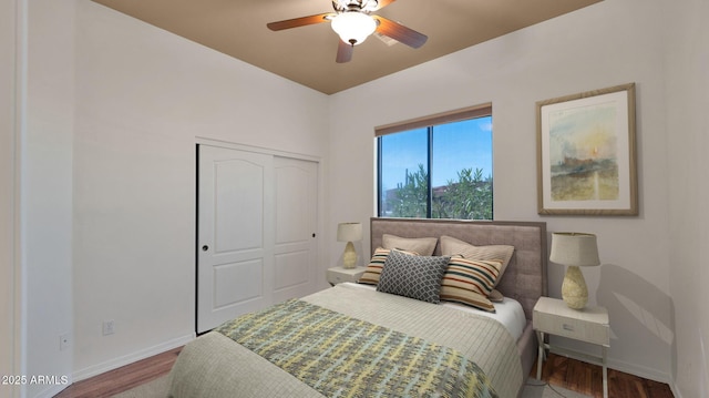 bedroom with ceiling fan, wood finished floors, a closet, and baseboards