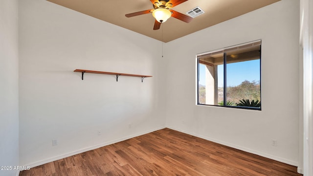 unfurnished room with ceiling fan, wood finished floors, visible vents, and baseboards