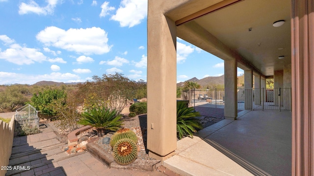 view of patio / terrace with a mountain view and fence