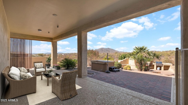 view of patio featuring an outdoor living space, a mountain view, fence, and a hot tub