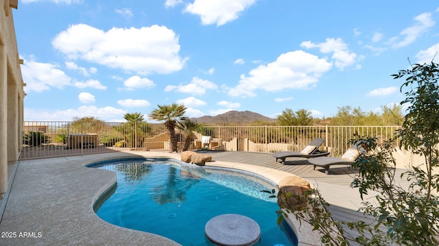 view of swimming pool featuring a patio area, a fenced in pool, fence, and a mountain view