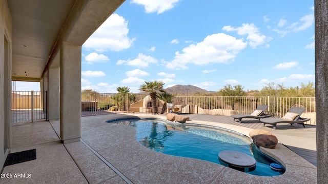 view of pool with a mountain view, a fenced in pool, and a patio area