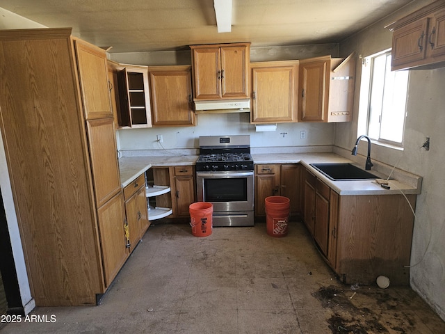 4110 E Wagoner Rd, Phoenix, AZ 85032 - kitchen with gas range, under cabinet range hood, light countertops, and brown cabinets
