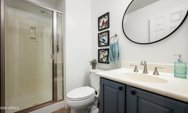 bathroom with vanity, toilet, and a shower with door