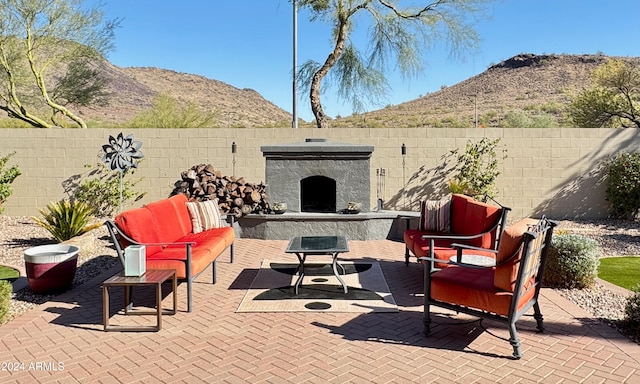 view of patio featuring an outdoor living space with a fireplace and a mountain view