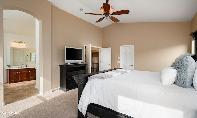 carpeted bedroom with ensuite bathroom, ceiling fan, sink, and high vaulted ceiling