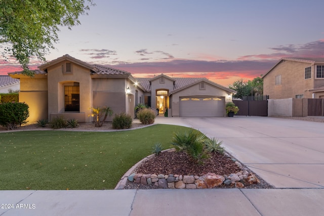 mediterranean / spanish-style home with a yard and a garage