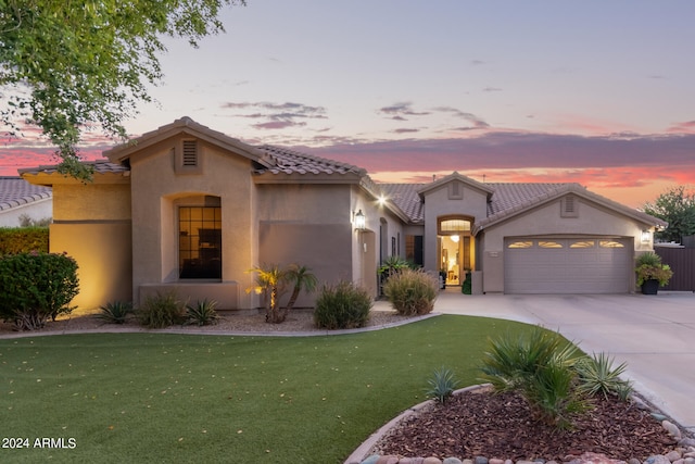 mediterranean / spanish-style house with a garage and a yard