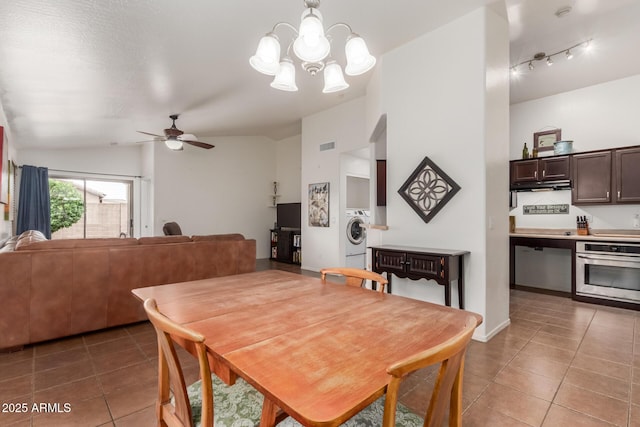 tiled dining space featuring washer / clothes dryer, a chandelier, ceiling fan, and vaulted ceiling
