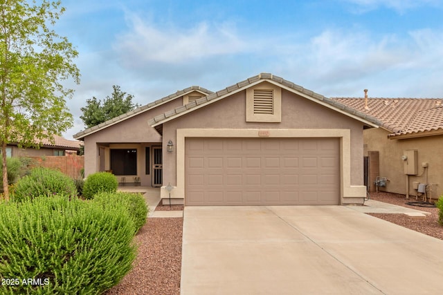 ranch-style home featuring a garage, stucco siding, driveway, a tiled roof, and fence