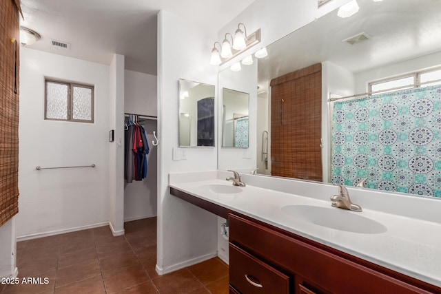 bathroom with tile patterned floors, double vanity, a shower with shower curtain, baseboards, and a spacious closet