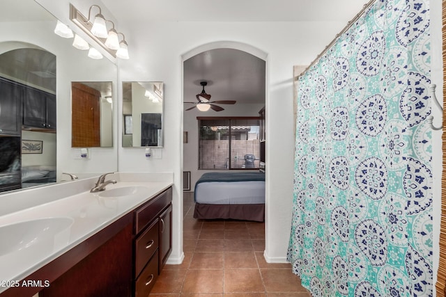 bathroom featuring ceiling fan, ensuite bathroom, tile patterned flooring, double vanity, and a shower with curtain