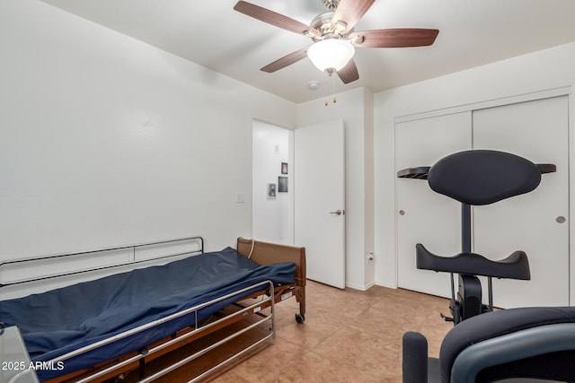 bedroom with ceiling fan, light tile patterned floors, and a closet