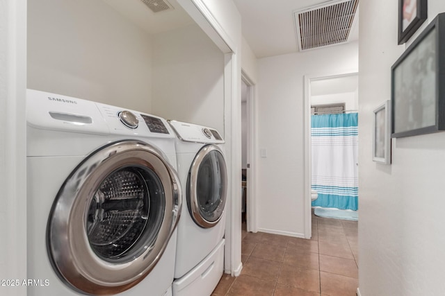 washroom with independent washer and dryer, tile patterned floors, and baseboards