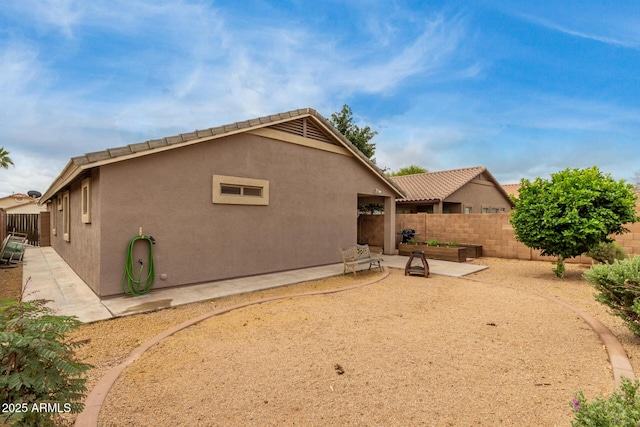 back of house with a patio, a fenced backyard, and stucco siding