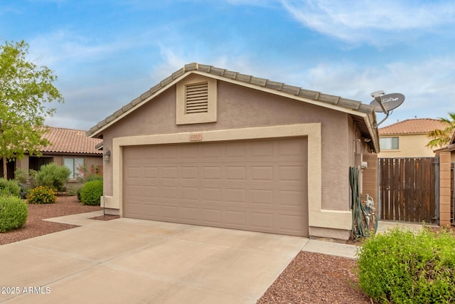 view of front facade featuring stucco siding, driveway, a tiled roof, and an attached garage