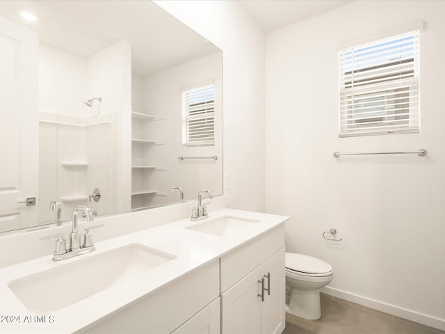 bathroom featuring vanity, plenty of natural light, tile patterned floors, and toilet