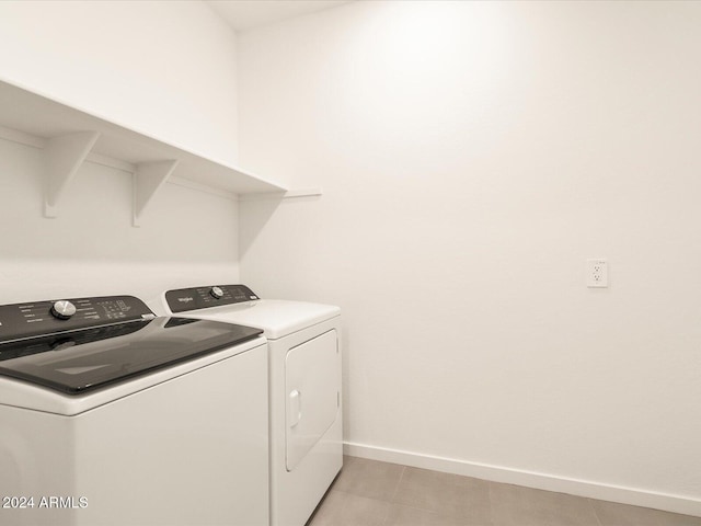 clothes washing area with light tile patterned floors and independent washer and dryer