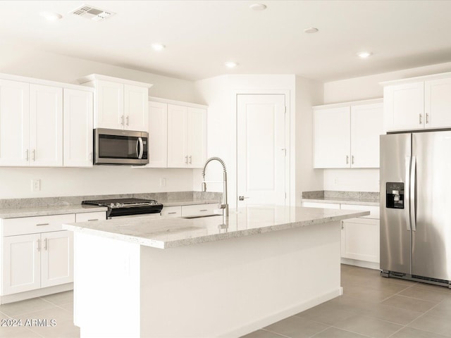 kitchen with stainless steel appliances, sink, a kitchen island with sink, and white cabinets