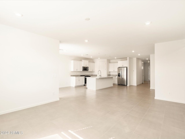 unfurnished living room with sink and light tile patterned floors