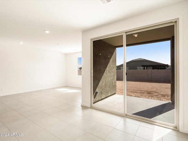 empty room with a wealth of natural light and light tile patterned floors