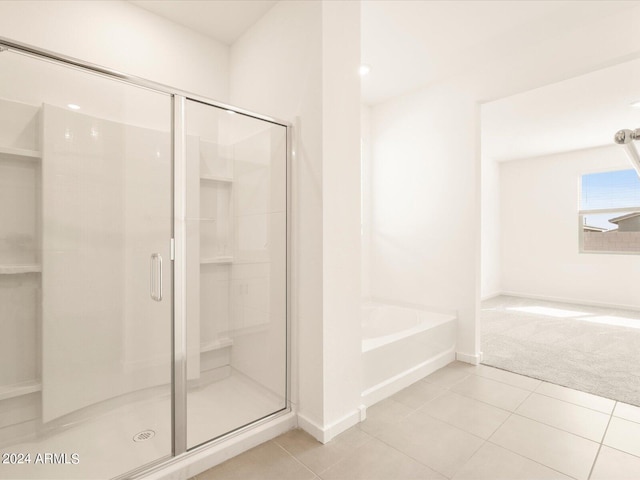 bathroom with independent shower and bath and tile patterned flooring