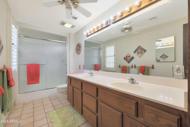 bathroom with tile patterned floors, vanity, a shower with shower door, and toilet