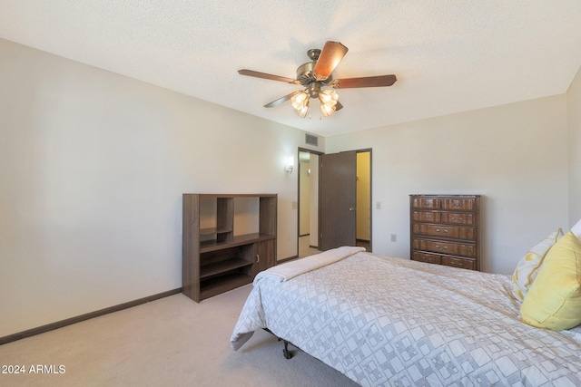 carpeted bedroom featuring ceiling fan and a textured ceiling