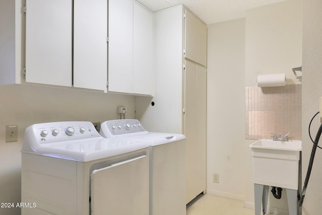 washroom featuring cabinets and washing machine and clothes dryer