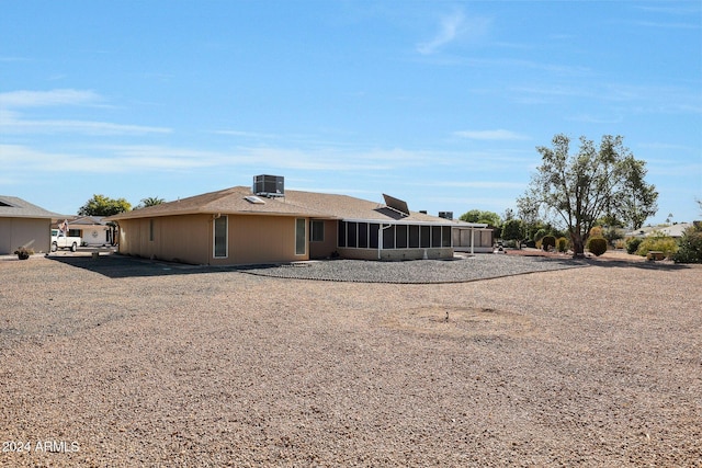 rear view of property featuring a sunroom and cooling unit