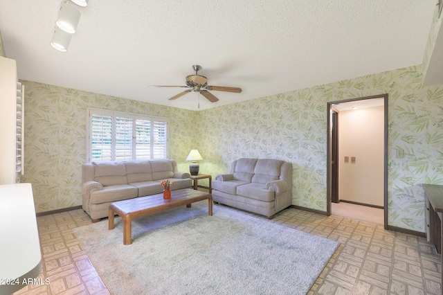 living room featuring ceiling fan and a textured ceiling