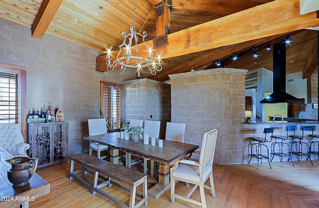 dining area with wood ceiling, a notable chandelier, wood-type flooring, vaulted ceiling with beams, and sink