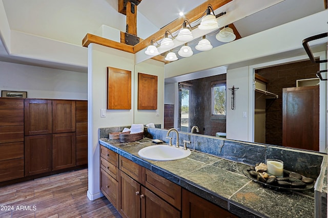 bathroom featuring lofted ceiling, vanity, and hardwood / wood-style flooring