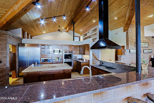 kitchen with high vaulted ceiling, kitchen peninsula, sink, and a wood stove