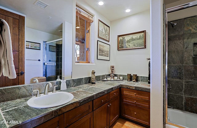 bathroom with bath / shower combo with glass door and vanity