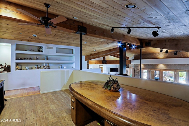 dining room with vaulted ceiling with beams, light wood-type flooring, wood ceiling, built in shelves, and rail lighting