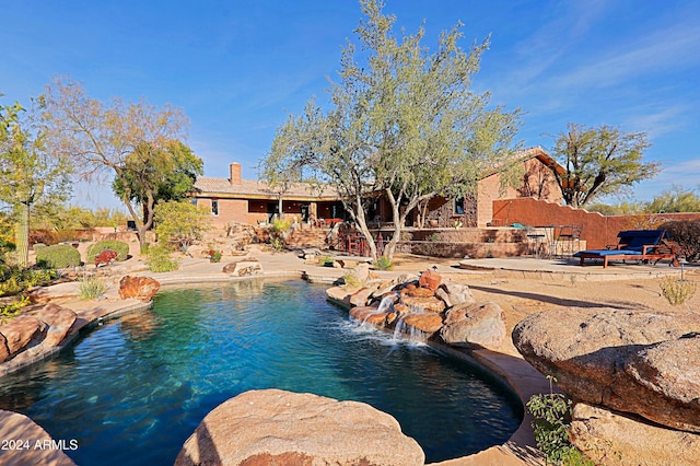 view of swimming pool featuring pool water feature and a patio area