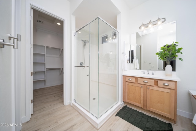 bathroom with a shower with door, vanity, and hardwood / wood-style floors