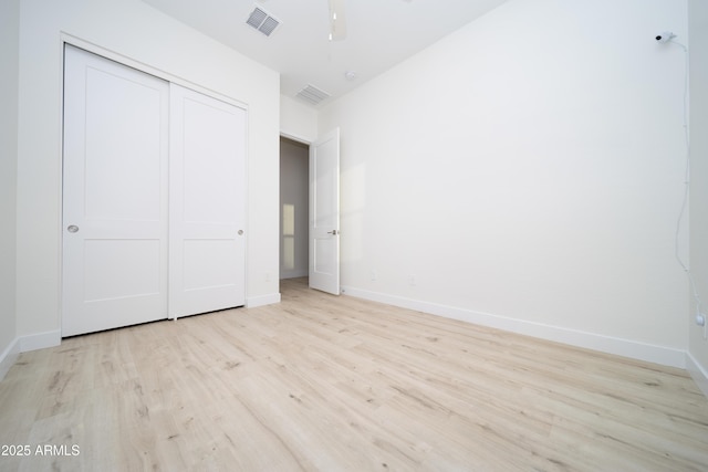 unfurnished bedroom featuring a closet and light hardwood / wood-style floors