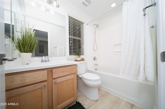 full bathroom with hardwood / wood-style floors, vanity, shower / bath combo, and toilet