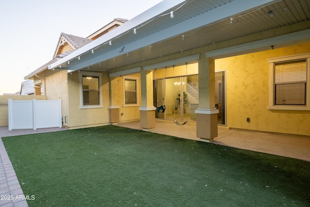 back of property featuring a patio and a lawn