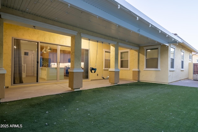 rear view of house with a lawn and a patio area