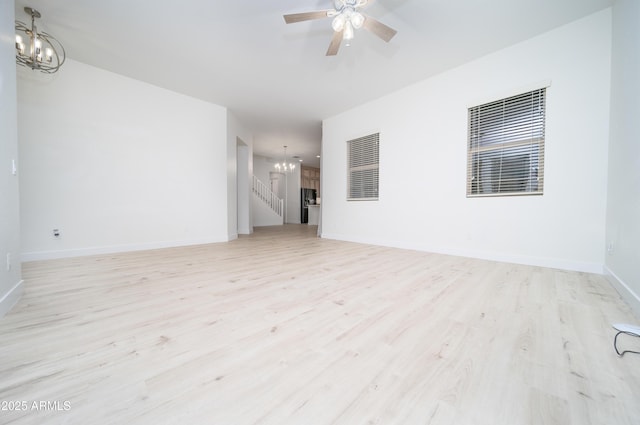 empty room featuring light hardwood / wood-style floors and ceiling fan with notable chandelier