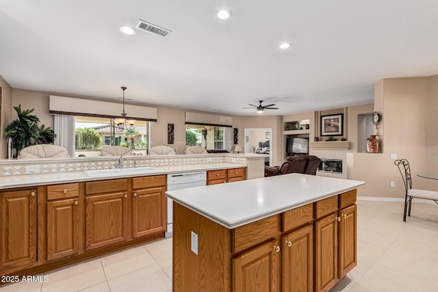 kitchen featuring sink, a center island, white dishwasher, pendant lighting, and ceiling fan with notable chandelier