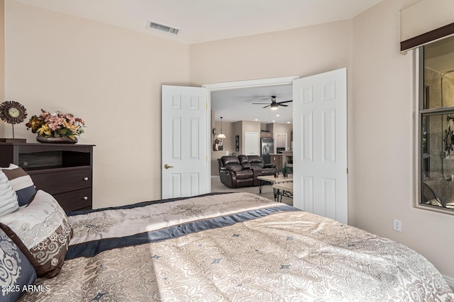 bedroom featuring stainless steel refrigerator with ice dispenser