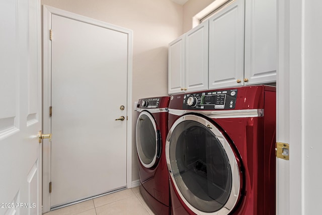 clothes washing area featuring independent washer and dryer, cabinets, and light tile patterned floors