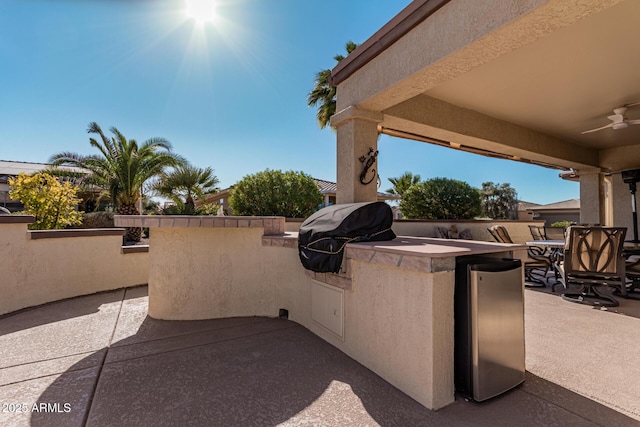 view of patio with ceiling fan, a grill, and exterior kitchen