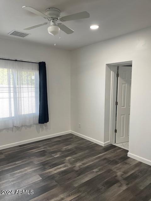 empty room with dark wood-type flooring and ceiling fan